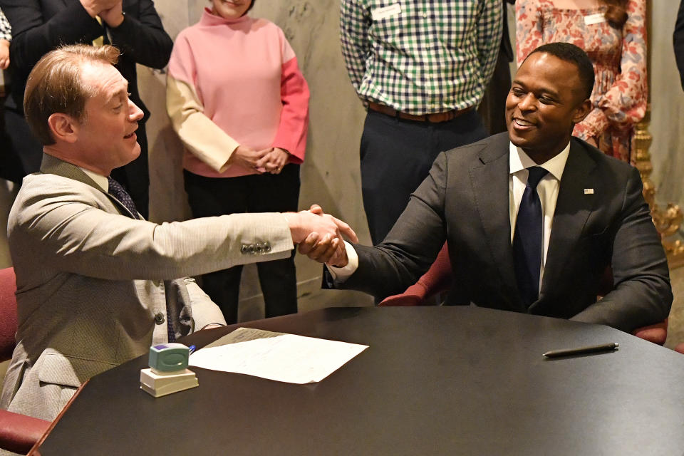 Kentucky Secretary of State Michael Adams, left, shakes hands with Kentucky Attorney General David Cameron after stamping the documents, officially filing to enter the race for Governor in Frankfort, Ky., Tuesday, Jan. 3, 2023. (AP Photo/Timothy D. Easley)