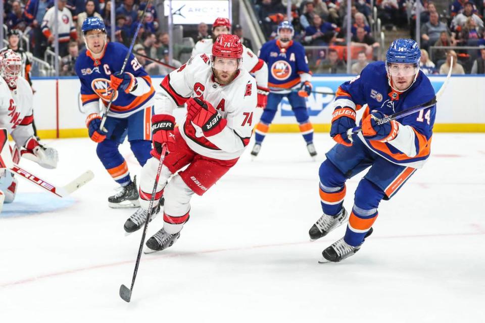 Apr 28, 2023; Elmont, New York, USA; Carolina Hurricanes defenseman Jaccob Slavin (74) and New York Islanders center Bo Horvat (14) chase the puck in game six of the first round of the 2023 Stanley Cup Playoffs at UBS Arena. Mandatory Credit: Wendell Cruz-USA TODAY Sports