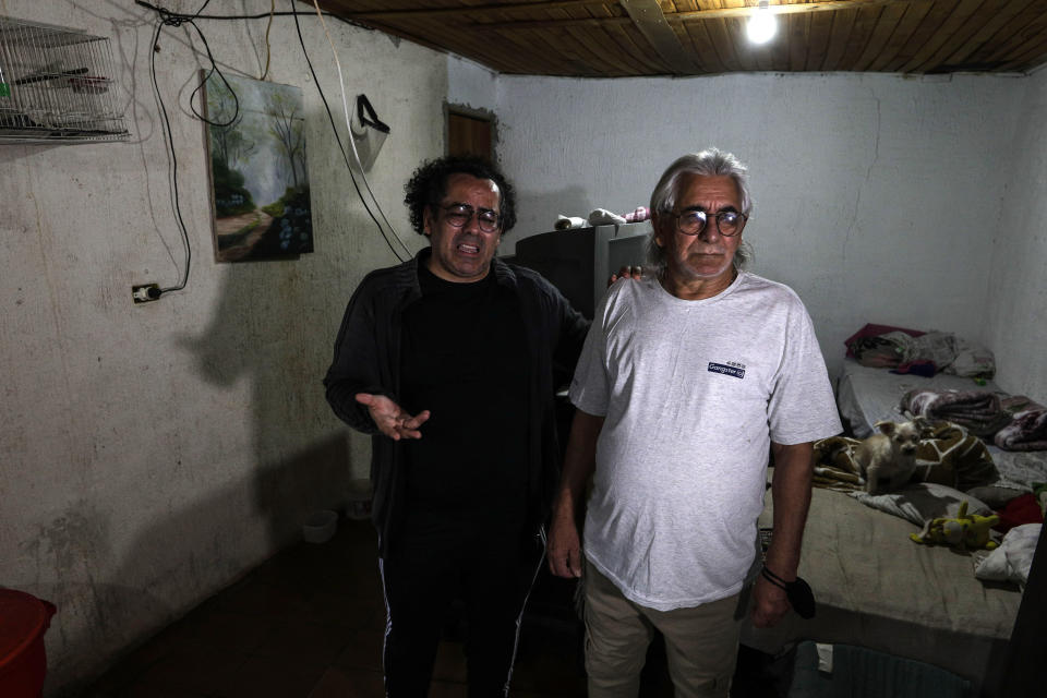 Luiz Cezar Pereira speaks next to his father Pedro Pereira Filho during an interview at their home in Guarulhos, Brazil, Friday, Oct. 1, 2021. Luiz's mother, Pedro's wife, died of COVID-19 and was treated by health care company Prevent Senior, which is under investigation for allegedly forcing doctors to test unproven drugs on coronavirus patients. She was treated with flutamide, a drug typically used for prostate cancer, for which Luiz eventually consented after resisting when his online research found it wasn’t scientifically proven. (AP Photo/Marcelo Chello)