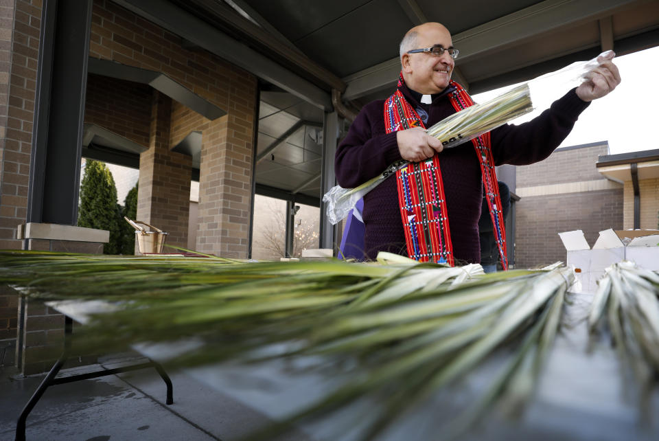 Our Lady's Immaculate Heart Catholic Church pastor Fr. Michael Amadeo sorts palms for Palm Sunday to be delivered via drive-thru in response to the coronavirus outbreak, Saturday, April 4, 2020, in Ankeny, Iowa. The new coronavirus causes mild or moderate symptoms for most people, but for some, especially older adults and people with existing health problems, it can cause more severe illness or death. (AP Photo/Charlie Neibergall)