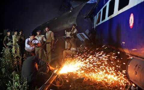 Indian police watch as rescue work is in progress - Credit: AP Photo/Altaf Qadri