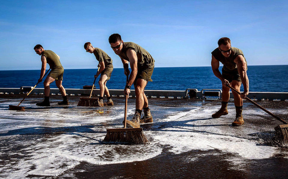 Marines with Marine Medium Tiltrotor Squadron 163 (Reinforced), 11th Marine Expeditionary Unit, scrub the flight deck of the amphibious assault ship USS Makin Island (LHD 8), Feb. 8, 2015.