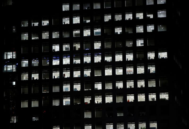 FILE PHOTO: Office lighting is seen through windows of a high-rise office building in Tokyo