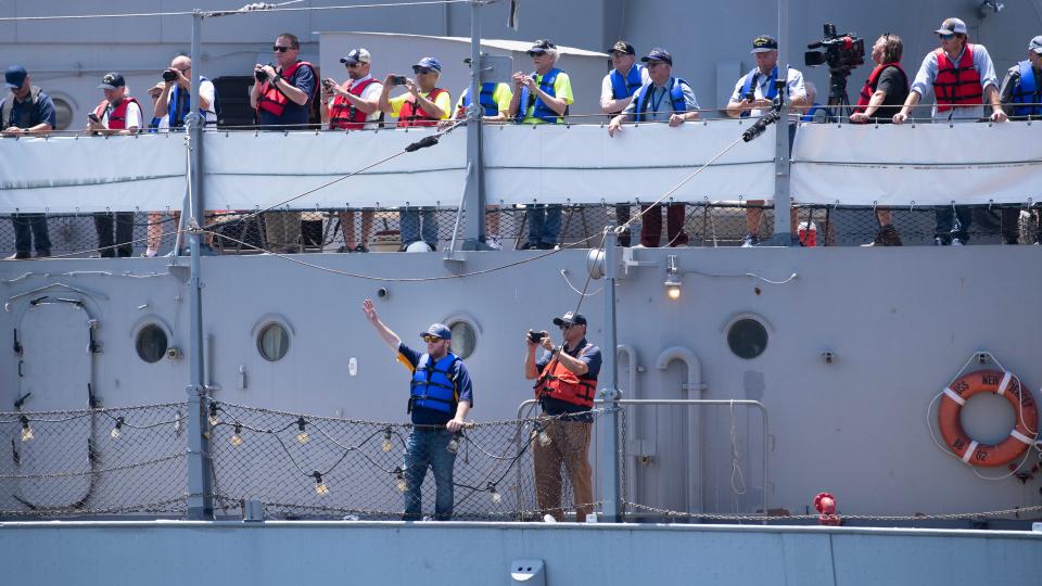 Marshall Spevak, the CEO of Battleship New Jersey, waves to the crowd as he stands on board the Battleship New Jersey after the battleship returned to the Camden Waterfront on Thursday, June 20, 2024, after spending nearly 12 weeks at the Philadelphia Navy Yard for a historic dry dock maintenance project.