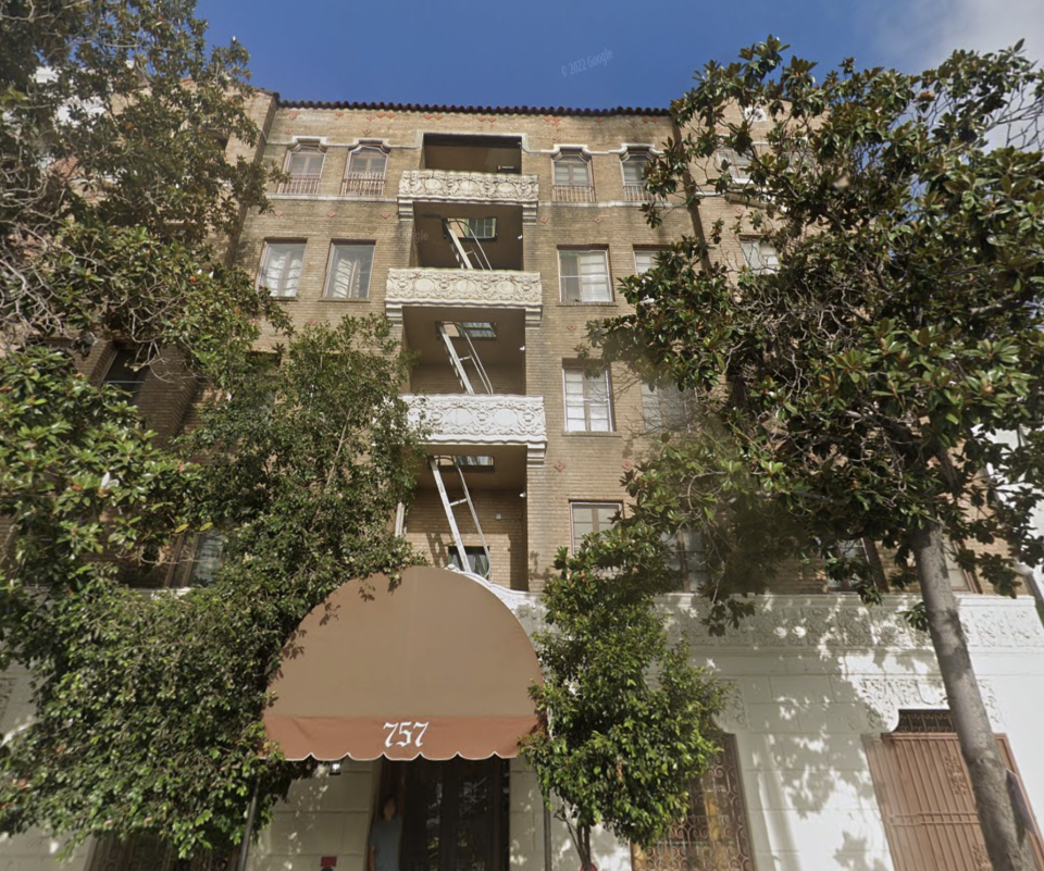 Exterior of an apartment building with balconies and a large awning over the entrance