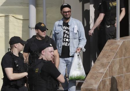 Russian theatre director Kirill Serebrennikov (C), who was accused of embezzling state funds, is escorted outside a court building after a hearing on his detention in Moscow, Russia August 23, 2017. REUTERS/Tatyana Makeyeva