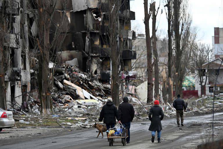 Un grupo de personas pasa por delante de edificios destruidos en la ciudad de Borodyanka, al noroeste de Kiev