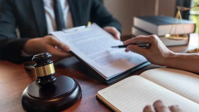 A lawyer works with a client on legal papers.