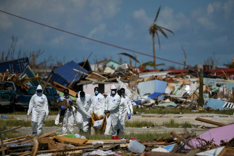 Royal Bahamas Police Force carry a body from the debris in Marsh Harbour, Great Abaco (REUTERS)