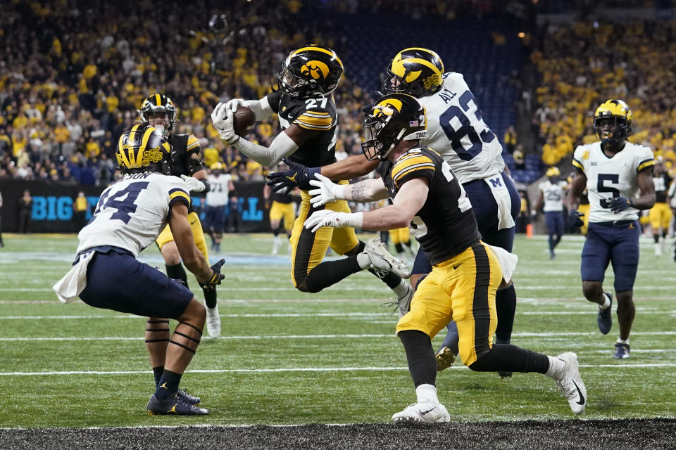 Iowa defensive back Jermari Harris (27) intercepts a pass intended for Michigan wide receiver Roman Wilson, left, during the first half of the Big Ten championship NCAA college football game, Saturday, Dec. 4, 2021, in Indianapolis. (AP Photo/Darron Cummings)