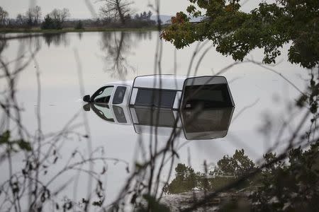 A truck sits in the flooded waters of the Stillaguamish River in Stanwood, Washington November 18, 2015. REUTERS/David Ryder