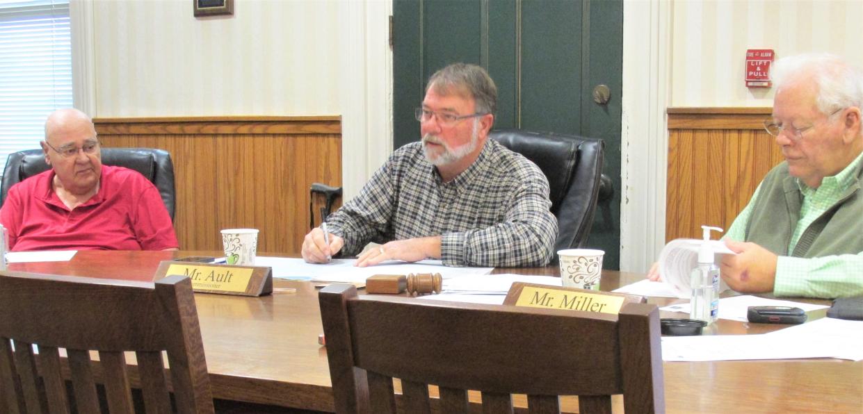 Holmes County Commissioners Ray Eyler (left), Rob Ault and Joe Miller discuss the recommended speed limit change on County Road 58 during their weekly meeting Monday.