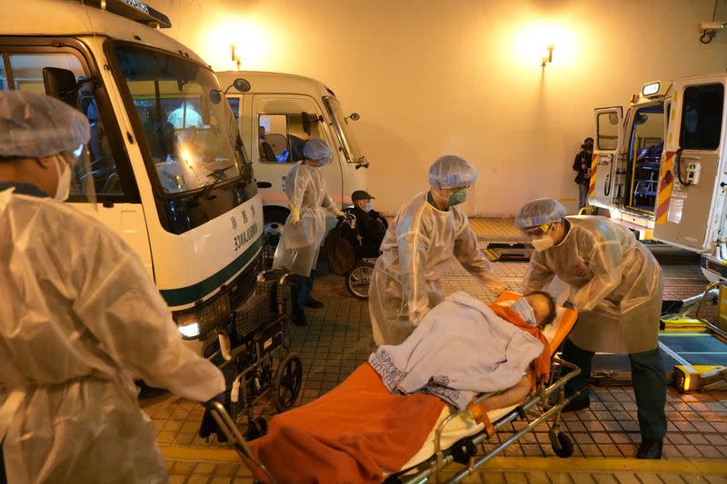 Health workers move elderly people to ambulances to transfer them to a government quarantine facility following a new COVID-19 outbreak, in Hong Kong