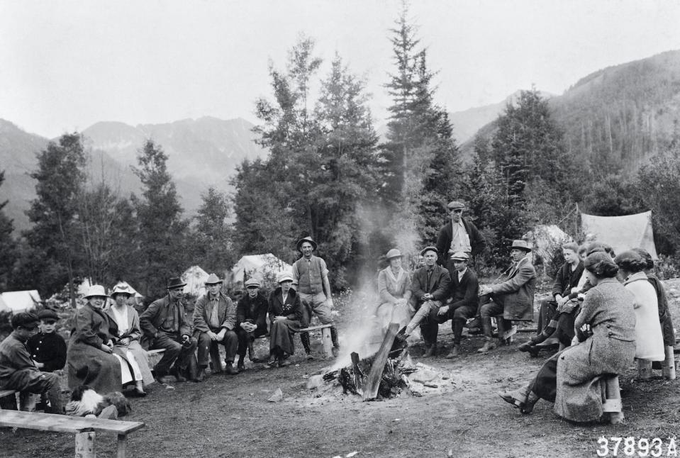 Hikers from the Colorado Mountain Club sit around a campfire on a hike through the Holy Cross National Forest near Ashcroft in 1917.