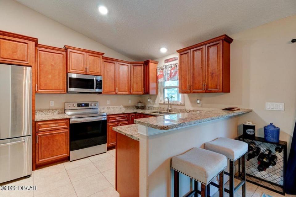 Updated tile flooring flows into the lovely open kitchen with granite countertops, stainless-steel appliances and updated soft-close cabinets and fixtures.