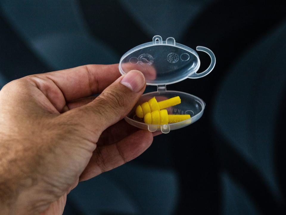 two yellow earplugs in a plastic container