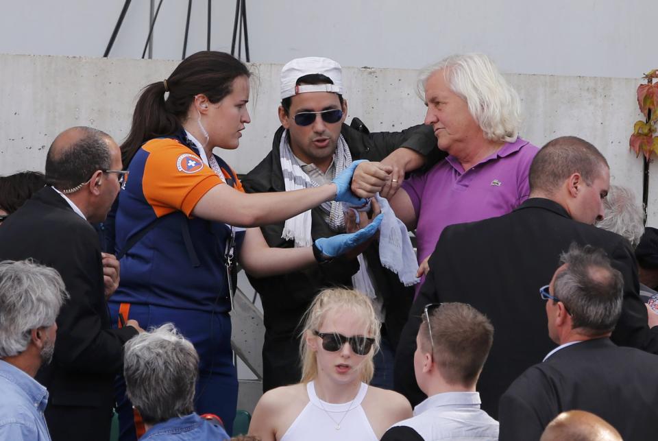 A spectator receives medical assistance after a metal structure collapsed in the tribune on the Philippe Chartier tennis court during the men's quarter-final match between Tsonga and Nishikori during the French Open tennis tournament in Paris