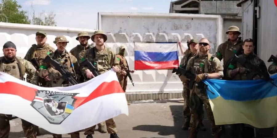 Belarusian volunteer fighters help Ukraine in the war against Russia, while Russian volunteer fighters, who support Ukraine, demonstrate their flag on the background