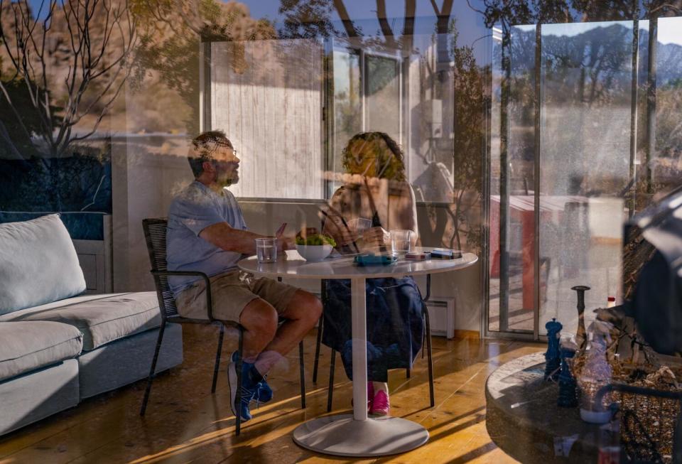 Desert landscape reflections set the ambience as Colin Campbell and his wife Gail play a favorite card game.