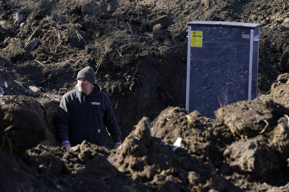 A worker stands in a trench near a bioreactor flow control structure, Friday, Feb. 10, 2023, in a field near Nevada, Iowa. Simple systems called bioreactors and streamside buffers help filter nitrates from rainwater before it can reach streams and rivers. (AP Photo/Charlie Neibergall)