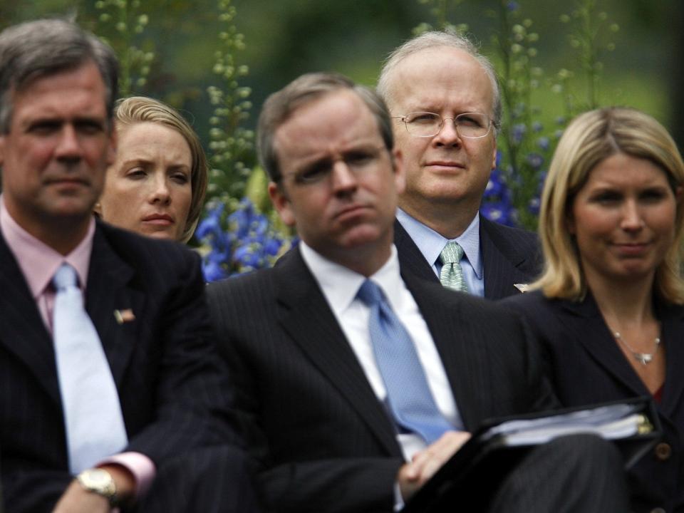 White House staff members (L-R) Tony Snow, Dana Perino, Dan Bartlett, Karl Rove and Nicole Wallace listen to United States President George W. Bush as he holds a press conference in the Rose Garden at the White House June 14, 2006 in Washington, DC.