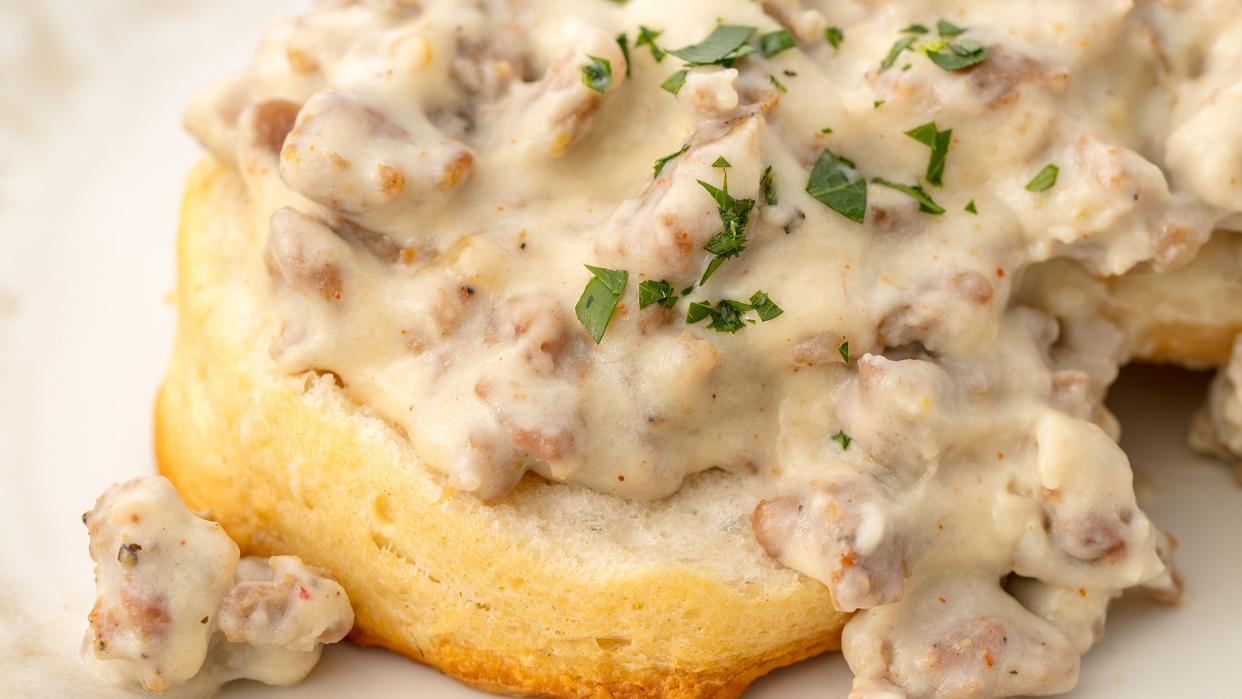 sausage gravy garnished with minced herbs on a piece of bread