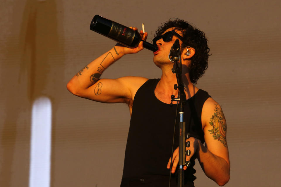 matty drinking wine from the bottle on stage