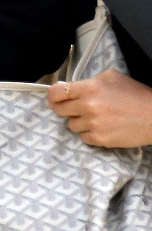 She was wearing her fine gold 'H' ring on her index finger.