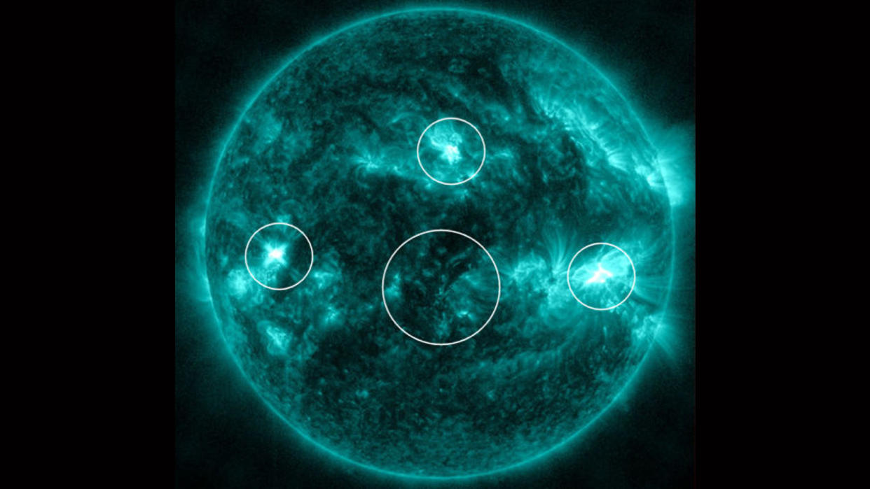  An image of the sun with four areas circled. 