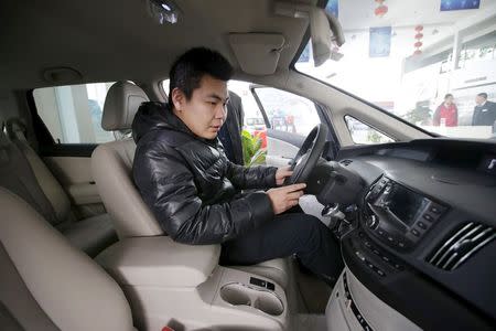 A customer checks a BYD e6 electric car at a dealership in Beijing, China, December 9, 2015. REUTERS/Jason Lee