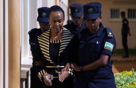 Adeline Rwigara, mother of Diane Shima Rwigara, a prominent critic of Rwanda's President Paul Kagame, is escorted by police officers into a courtroom in Kigali, Rwanda October 11, 2017. REUTERS/Jean Bizimana