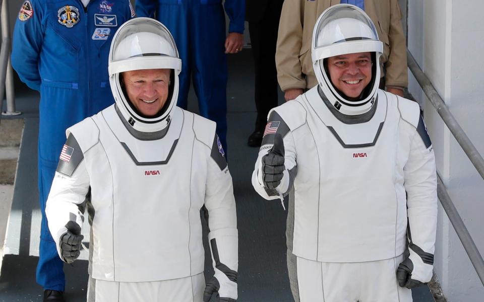 Douglas Hurley, left, and Robert Behnken prepare for the Crew Dragon capsule takeoff in May - John Raoux/AP