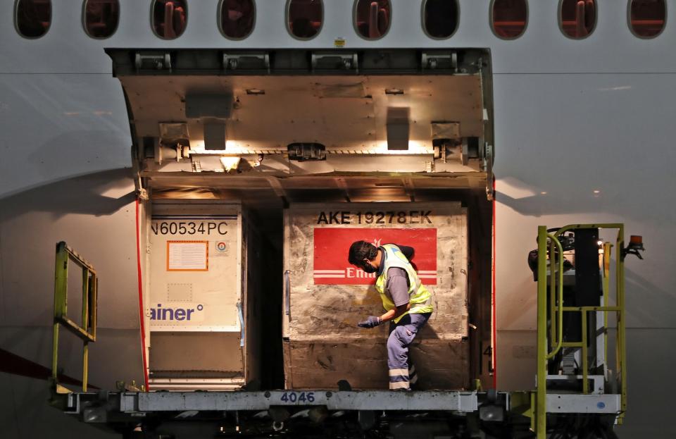CORRECTS DATE TO EARLY SUNDAY FEB. 21, 2021 -- A Pfizer-BioNTech COVID-19 coronavirus vaccines shipment is offloaded from an Emirates Airlines Boing 777 arrived from Brussels at Dubai International Airport in Dubai, United Arab Emirates, early Sunday, Feb. 21, 2021. As the coronavirus pandemic continues to clobber the aviation industry, Emirates Airlines, the Middle East’s biggest airline is seeking to play a vital role in the global vaccine delivery effort. (AP Photo/Kamran Jebreili)