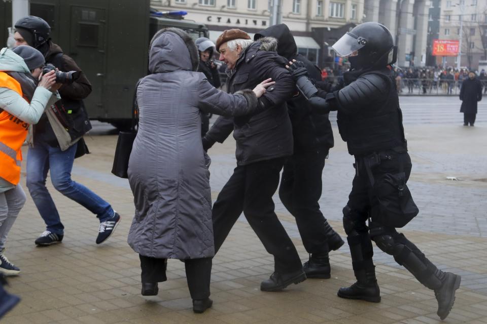 Belarus police detain a man, as a woman tries to defend him during an opposition rally in Minsk, Belarus, Saturday, March 25, 2017. A cordon of club-wielding police blocked the demonstrators' movement along Minsk's main avenue near the Academy of Science. Hulking police detention trucks were deployed in the city center. (AP Photo/Sergei Grits)