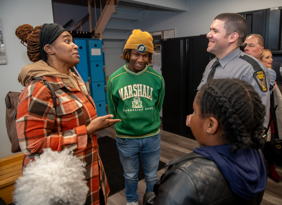 Ohio State Highway Patrol Trooper Jose Molina-Mendez, right, chats with Antwon Watson, 16, and his mother, Akila Watson, after a ceremony Thursday to honor the trooper for saving Antwon's life during a medical emergency.