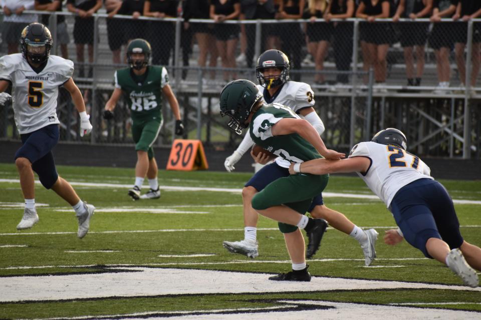 Mooresville's Branson Blair (27) and the Pioneers' defense attempt to wrap up Pendleton Heights' Isaac Wilson (13) during the two team's scrimmage on Aug. 12, 2022.