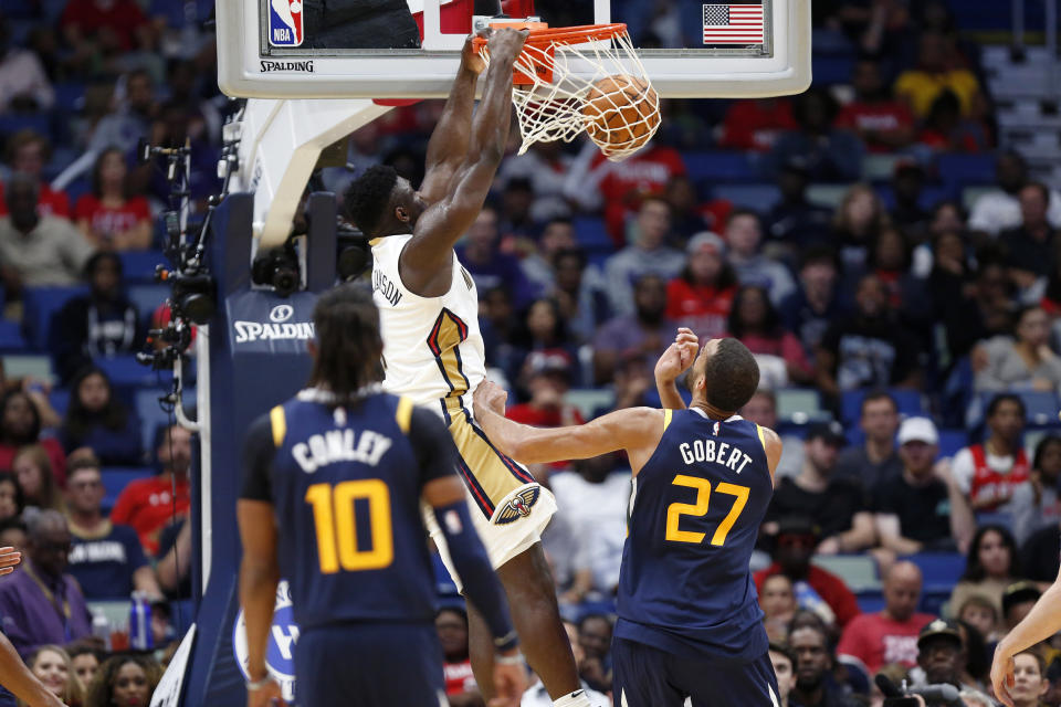 New Orleans Pelicans forward Zion Williamson (1) dunks over Utah Jazz center Rudy Gobert (27) during the second half of a preseason NBA basketball game in New Orleans, Friday, Oct. 11, 2019. (AP Photo/Tyler Kaufman)