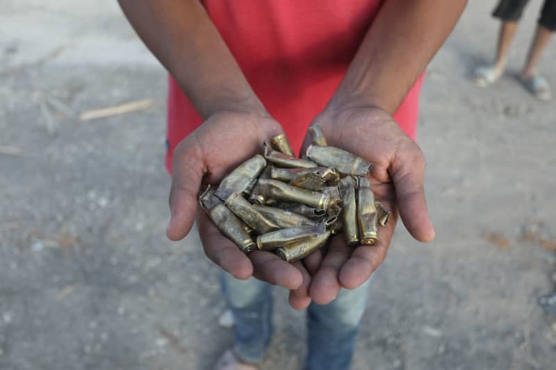 A Palestinian holds empty rifle cartridges after the Israeli army's withdrawal from the eastern part of Deir al-Balah Abed Rahim Khatib/dpa