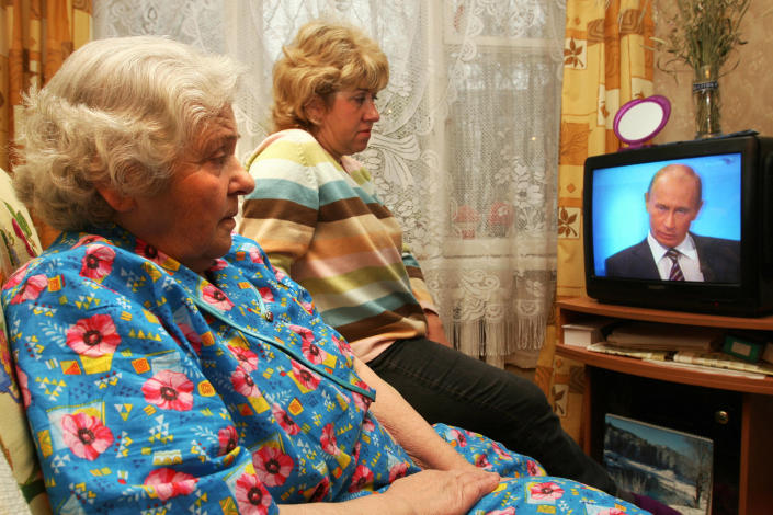 Two Russian women Olga (L) and her daughter Nadia (R) watch Russian Prime Minister Vladimir Putin taking questions during a nationally televised town-hall style session in Shcherbika on December 4, 2008. Putin ruled out early presidential elections, saying the next presidential ballot in Russia would be held as scheduled in 2012.<span class="copyright">Andrei Smirnov —AFP/Getty Images</span>