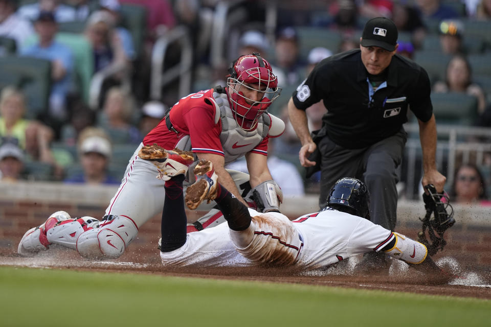 Philadelphia Phillies catcher J.T. Realmuto (10) tags out Atlanta Braves' Ozzie Albies (1) in the first inning of a baseball game, Sunday, May 28, 2023, in Atlanta. (AP Photo/Brynn Anderson)