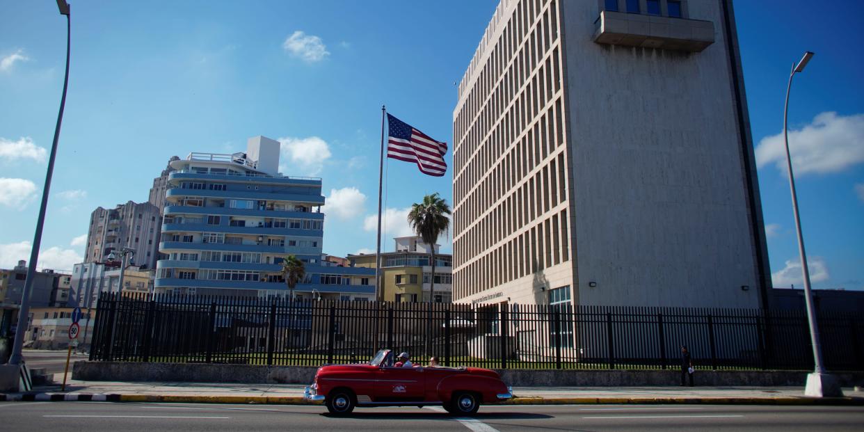 FILE PHOTO: Tourists in a vintage car pass by the U.S. Embassy in Havana, Cuba, November 7, 2019. REUTERS/Alexandre Meneghini