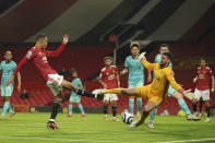 Liverpool's goalkeeper Alisson, right, makes a save in front of Manchester United's Mason Greenwood during the English Premier League soccer match between Manchester United and Liverpool, at the Old Trafford stadium in Manchester, England, Thursday, May 13, 2021. (AP Photo/Dave Thompson, Pool)