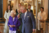 FILE - In this Tuesday, March 5, 2019 file photo, Britain's Queen Elizabeth II is joined by Prince Charles, the Prince of Wales, and at rear, from left, Kate, Duchess of Cambridge, Camilla, Duchess of Cornwall, Prince William, Prince Harry and Meghan, Duchess of Sussex during a reception at Buckingham Palace, London, to mark the fiftieth anniversary of the investiture of the Prince of Wales. Britain and its royal family are absorbing the tremors from a sensational television interview with Prince Harry and Meghan. The couple said they encountered racist attitudes and a lack of support that drove Meghan to thoughts of suicide. The couple gave a deeply unflattering depiction of life inside the royal household, depicting a cold, uncaring institution that they had to flee to save their lives. Meghan told Oprah Winfrey that at one point “I just didn’t want to be alive anymore.” Meghan, who is biracial, said that when she was pregnant with son Archie, there were “concerns and conversations about how dark his skin might be when he’s born.” (Dominic Lipinski/Pool via AP, File)