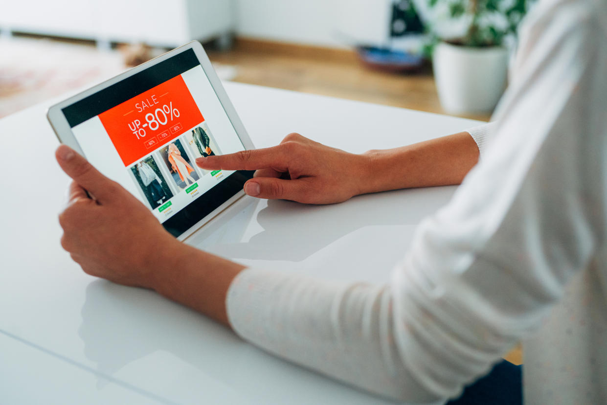 Young woman holding a digital tablet and shopping online at home.