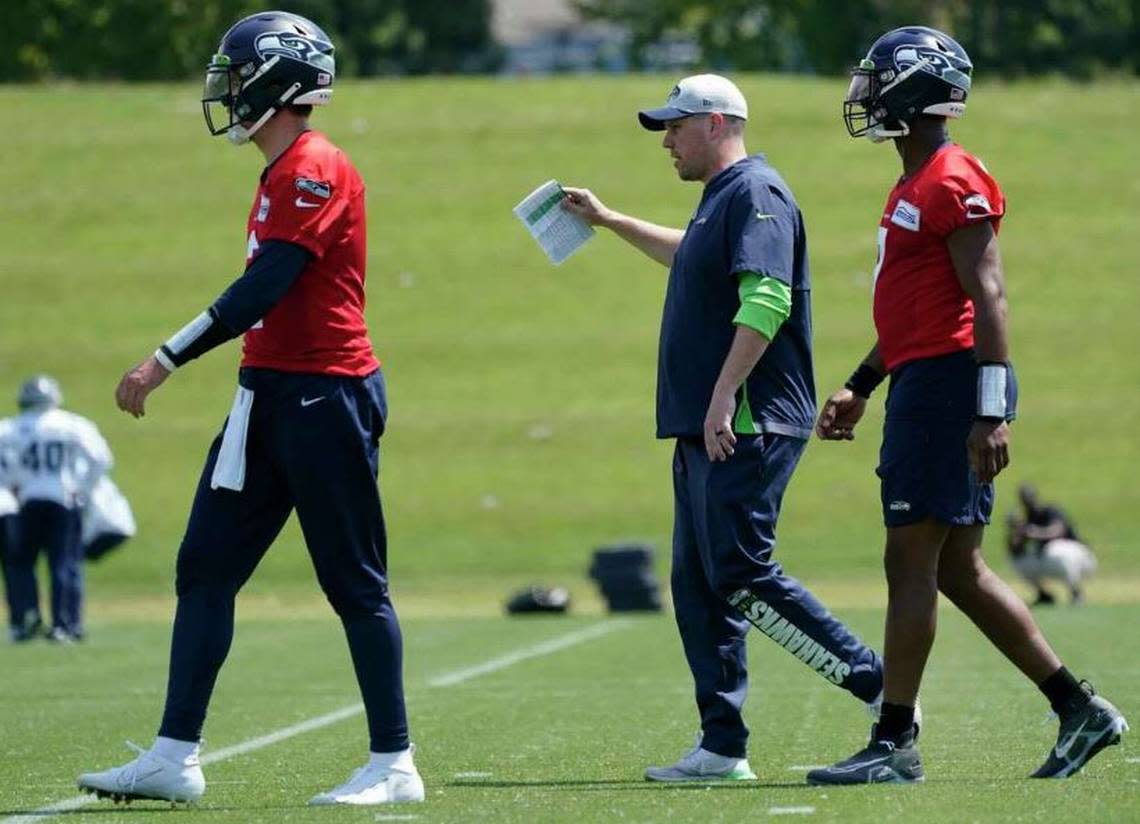 Offensive coordinator and play caller Shane Waldron (center) between quarterbacks Drew Lock (left) and Geno Smith (right) during Seahawks organized team activities (OTAs) practice, May 23, 2022, at team headquarters in Renton.