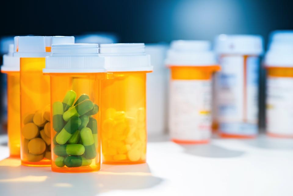 Pill bottles containing various prescription drugs on a table