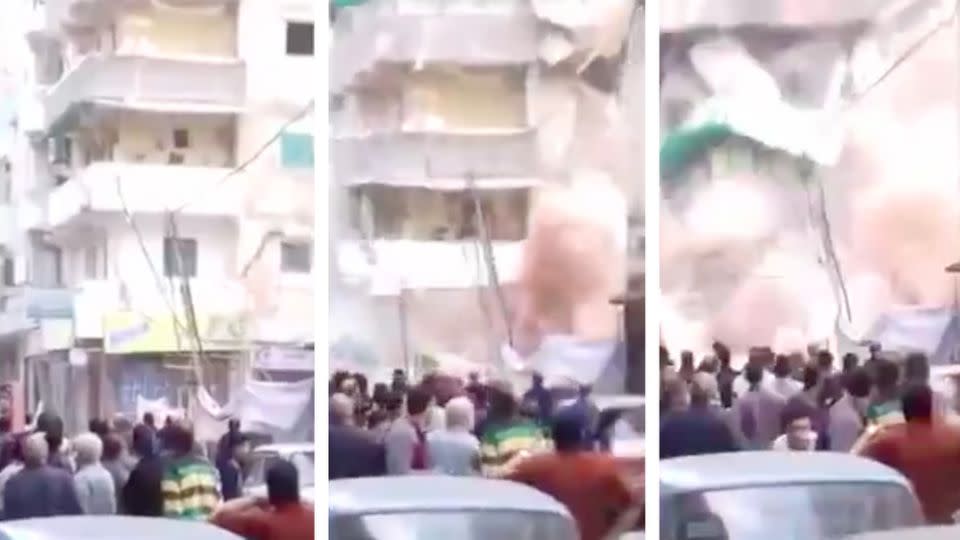 A huge cloud of dust engulfs the street as the building collapses in front of onlookers. Photo: LiveLeak