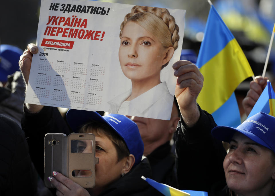 Supporters greet Former Ukrainian Prime Minister Yulia Tymoshenko, candidate for the 2019 presidential elections, during a rally in Kiev, Ukraine, Friday, March 29, 2019. Tymoshenko is running in the president election scheduled for March 31. The placard reading "To not give up! Ukraine will win!" (AP Photo/Sergei Grits)