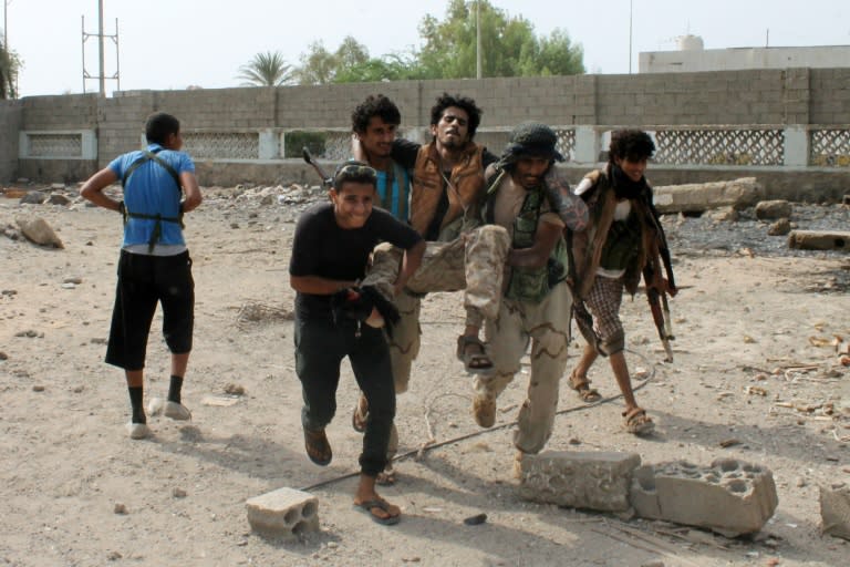 Yemeni fighters loyal to exiled President Abedrabbo Mansour Hadi evacuate an injured comrade during clashes with Shiite Huthi rebels on July 16, 2015 in Aden