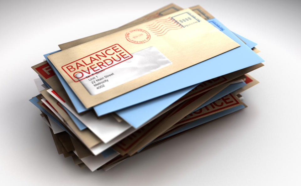A pile of envelopes with delivery stamps saying balance overdue symbolizing bills and debt on an isolated white background